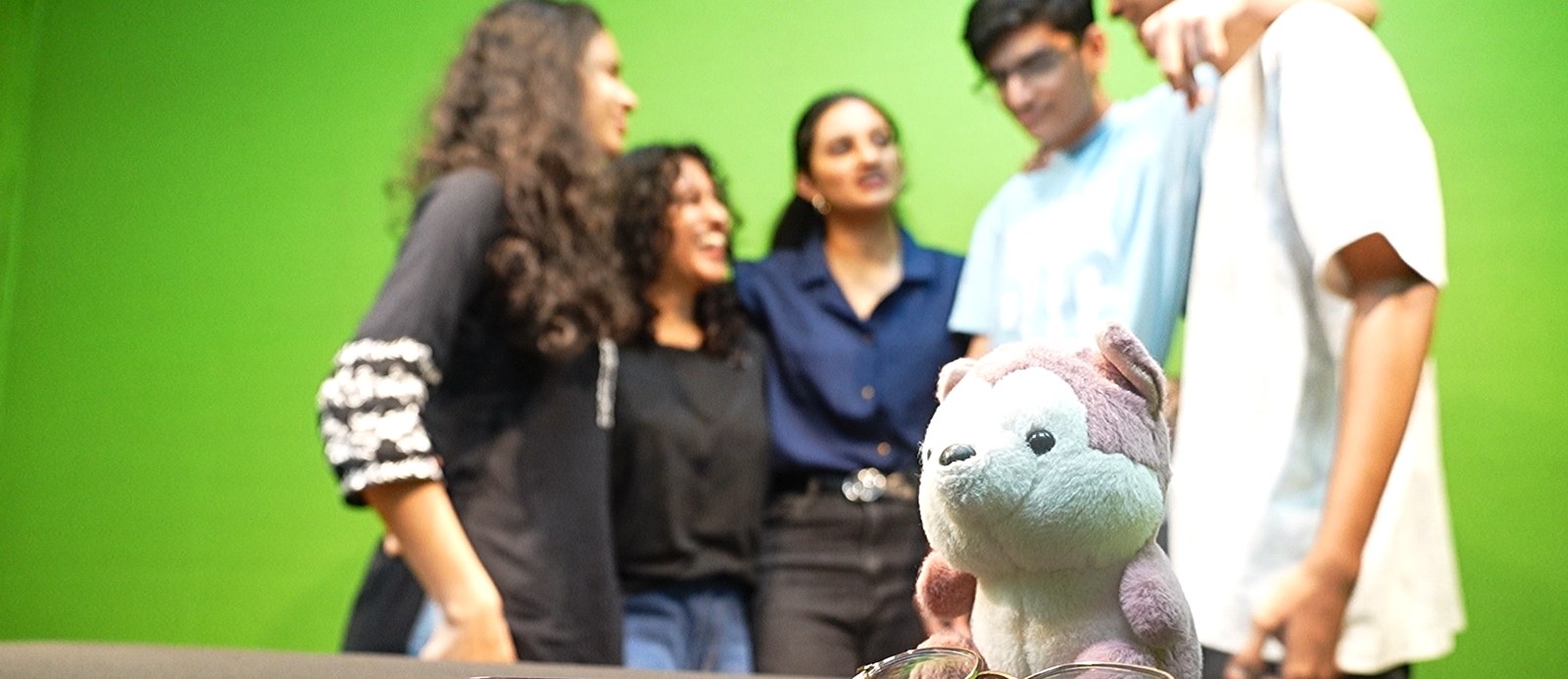 Studio photograph with a soft toy in sharp focus and journalism and mass communication students blurred in the background at PES University